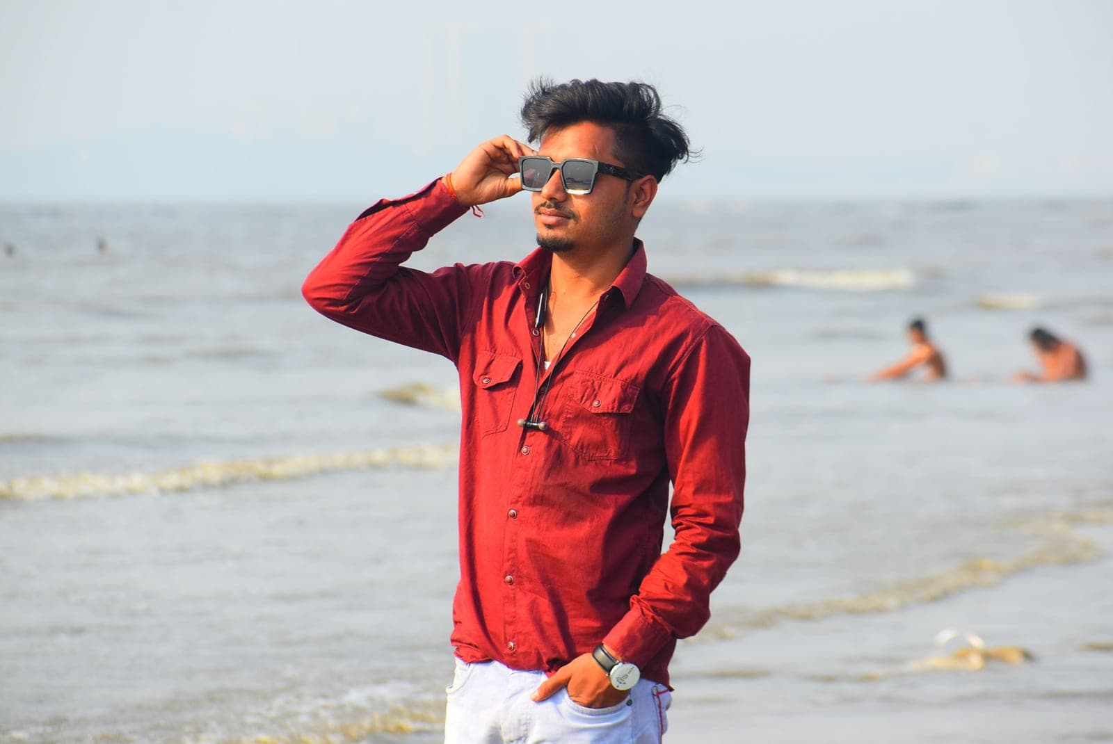 A person in sunglasses on a bright, sunlit beach